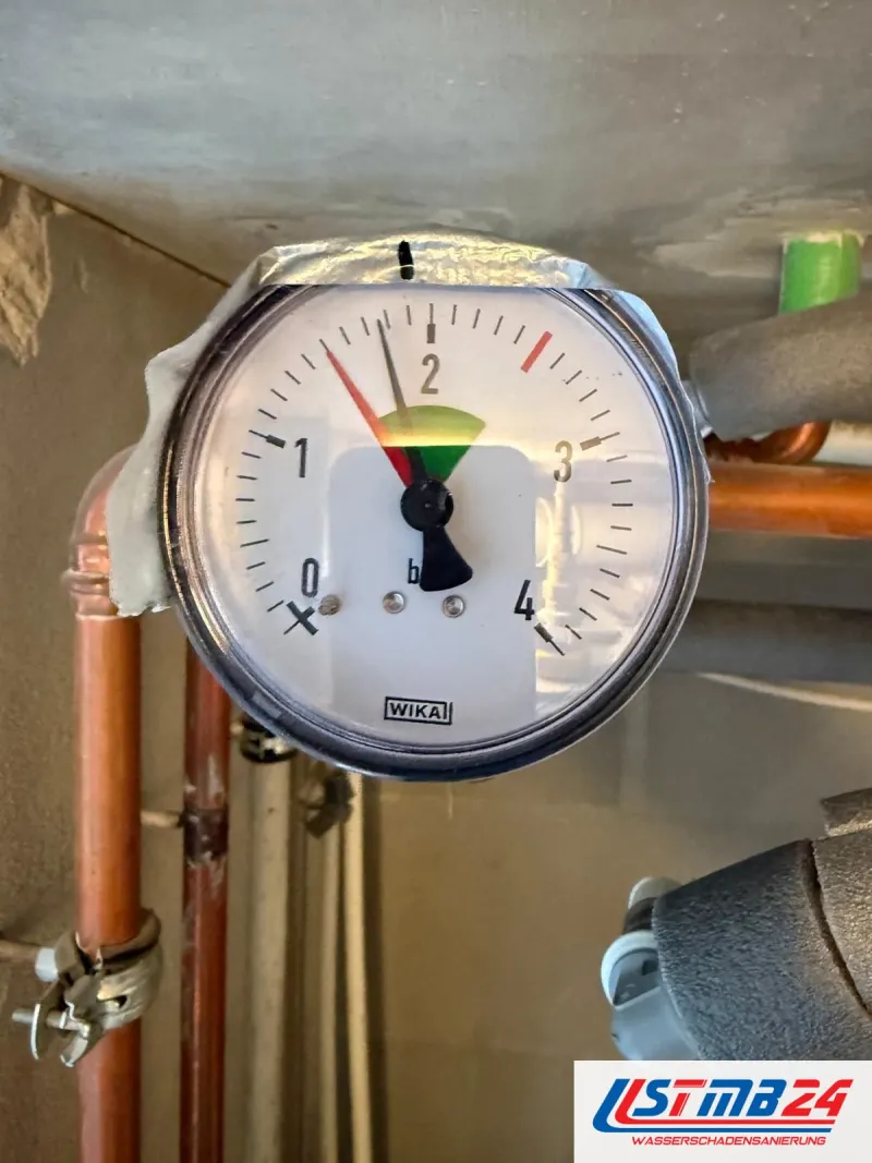 Manometer mit 1,2 bar an einer Kupferleitung während der Druckprobe, Messingarmatur, Keller im Hintergrund