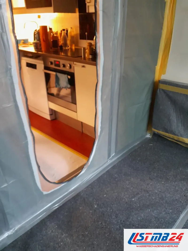 Staubschutzwand aus Folie mit Reißverschlusstür zur Küche, Vlies auf dem Boden, abgeklebte Möbel daneben