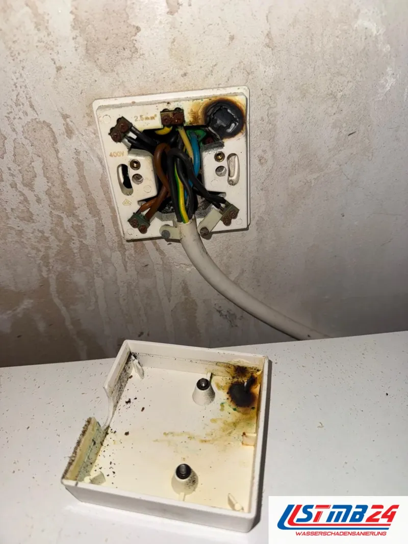 Elektroinstallation: geöffnete Geräteanschlussdose für 400 Volt mit Brandspuren an Klemmen und Adern, daneben der Deckel