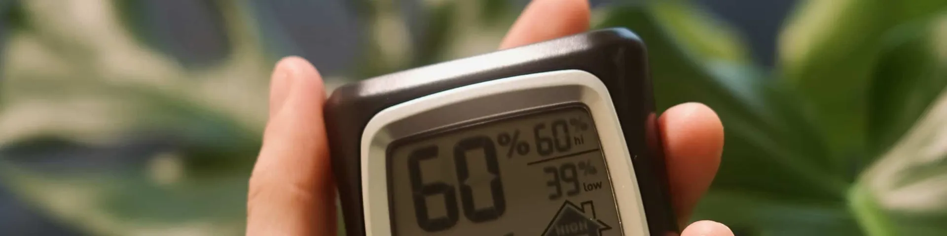 Feuchtigkeitsmessung: Hygrometer in der Hand zeigt 60 Prozent Luftfeuchte im Raum
