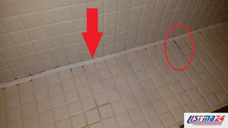 Fliesenarbeiten im Mosaik: Pfeil auf die Fuge an einer Kante in der Dusche, ein Kreis umfasst gerissene Fugen