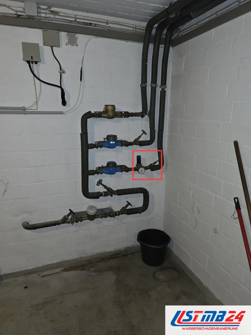 Heizung und Sanitärinstallation: Hausanschluss im Keller mit mehreren Wasserzählern und Absperrventilen, rot markiert der Druckminderer