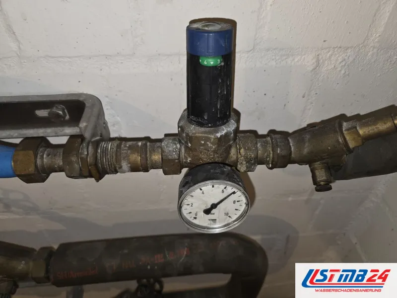 Heizung und Sanitärinstallation: Druckminderer mit grüner Einstellskala und Manometer, daneben ein Schrägsitzventil