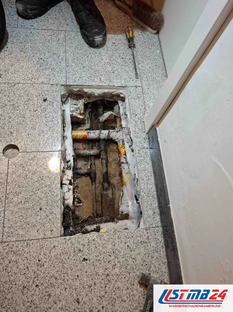 Nach der Ortung freigelegt: im Granitboden des Flurs ist ein Feld ausgeschnitten, darunter Kupferleitungen und nasse Schüttung