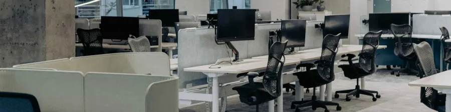 Jobs: Großraumbüro mit höhenverstellbaren Schreibtischen, Bildschirmen und schwarzen Bürostühlen