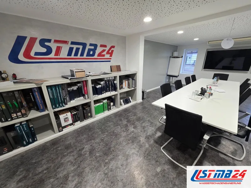 Kosten und Abwicklung: Besprechungsraum im STMB24-Büro mit großem Logo, Regal mit Ordnern und Musterkatalogen