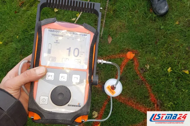 Leckageortung mit Tracergas: Sewerin Variotec 460 mit Bodenglocke zeigt 10 ppm Wasserstoff, die Fundstelle ist im Rasen orange markiert