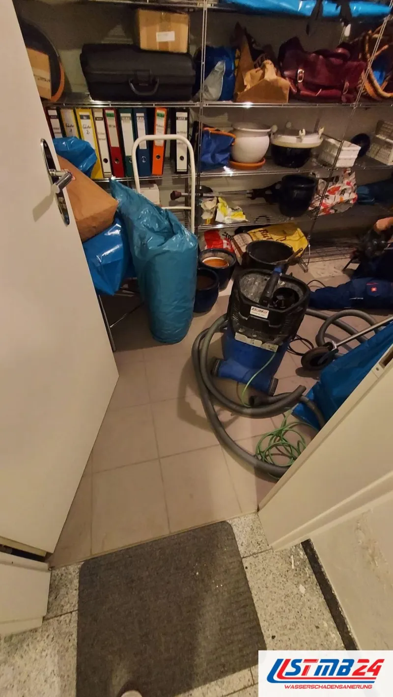 Bautrocknung in Geesthacht: Abstellraum mit Wassersauger, grauen Saugschläuchen und blauen Säcken vor dem Regal