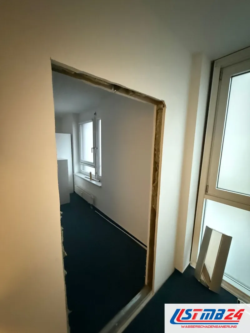 Trockenbau in Geesthacht: Türöffnung in der neuen Wand, Laibung mit Holzrahmen, dahinter ein Büro mit Fenster