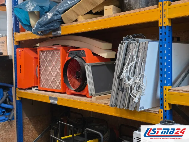 Trocknungsgerät mieten in Geesthacht: orangefarbener Luftreiniger, Axialventilator und Heylo-Gerät im Regal, rechts Infrarotplatten