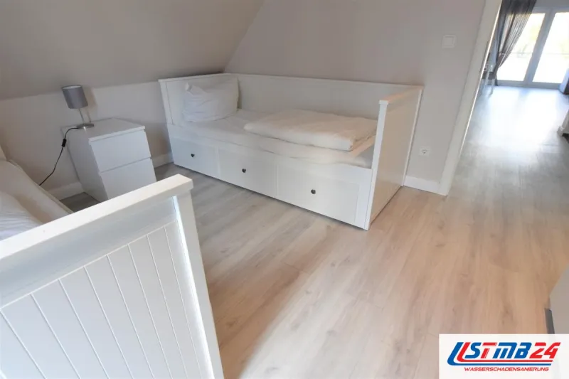 Bodenleger in Grömitz: heller Boden in Eichenoptik im Gästezimmer mit Tagesbett unter der Dachschräge