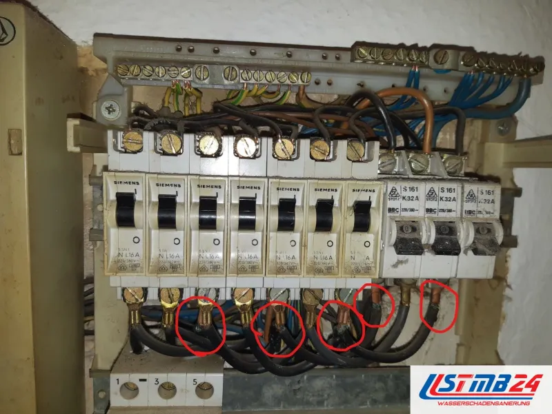 Elektriker in Grömitz: alter Sicherungskasten, rote Markierungen an den Anschlüssen der Leitungsschutzschalter