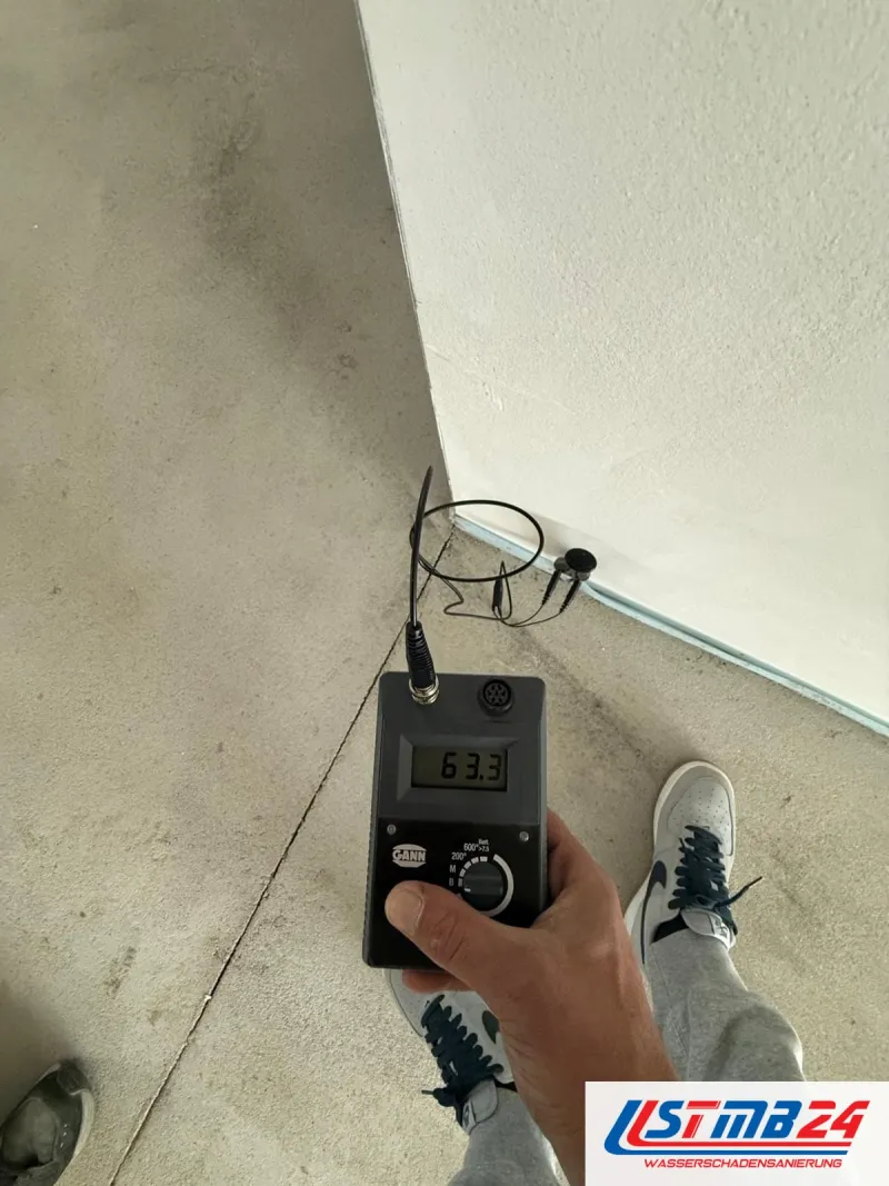 Feuchtigkeitsmessung in Grömitz: Hydromette mit Elektroden am Übergang von Wand und Estrich im Souterrain, Anzeige 63,3