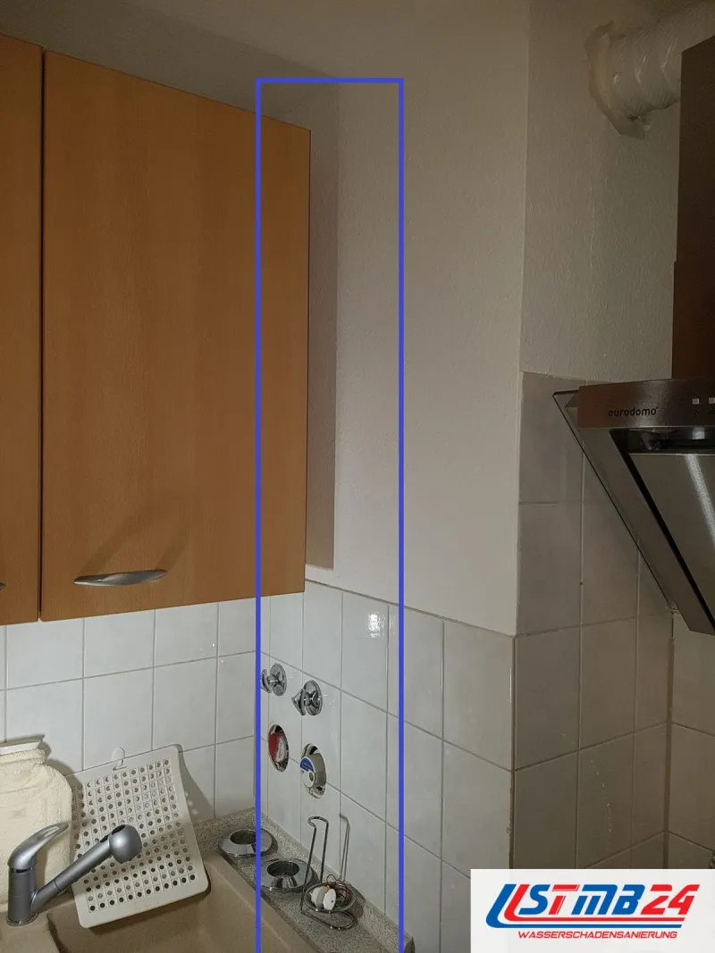 Küchenmontage in Grömitz: Hängeschrank in Buche, daneben markiert ein blauer Rahmen die Wandanschlüsse über der Spüle