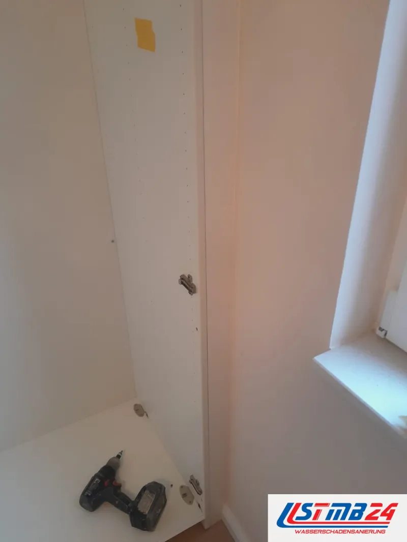 Küchenmontage in Grömitz, Schrankbau: weißer Hochkorpus mit Topfband, im unteren Fach der Akkuschrauber, rechts das Fenster