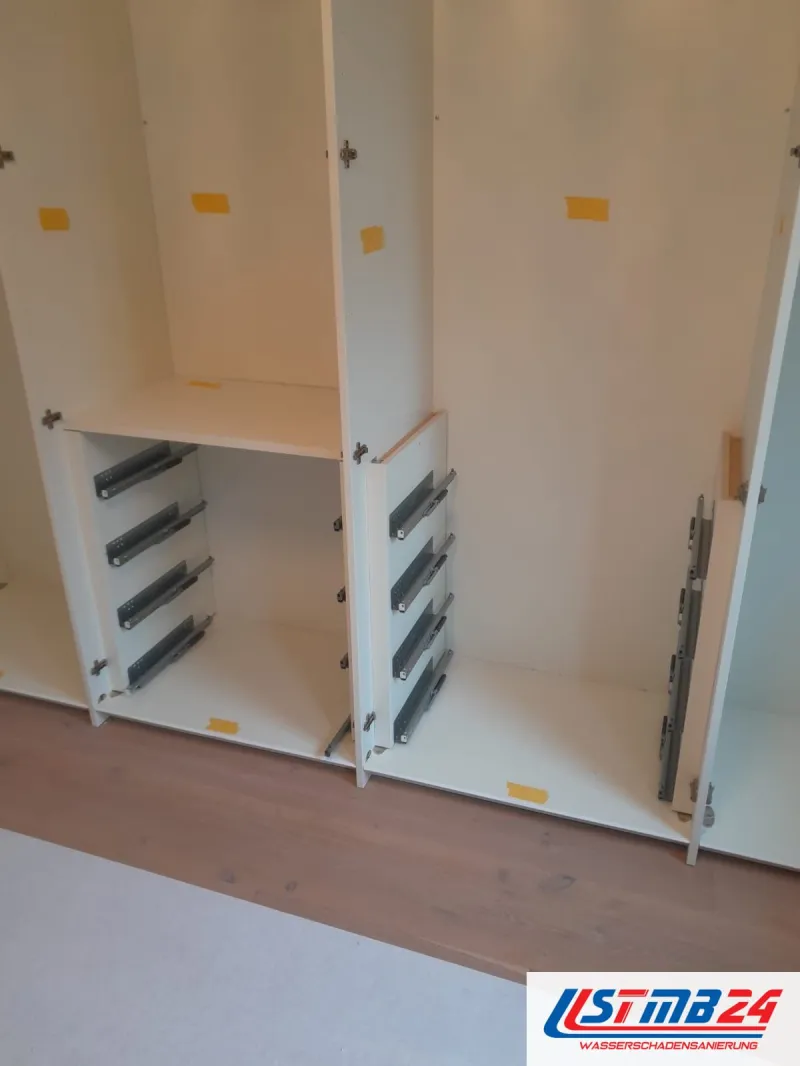 Küchenmontage in Grömitz, Schrankbau: Korpusse eines Einbauschranks mit Schubladenschienen, gelbe Klebepunkte, Boden mit Vlies