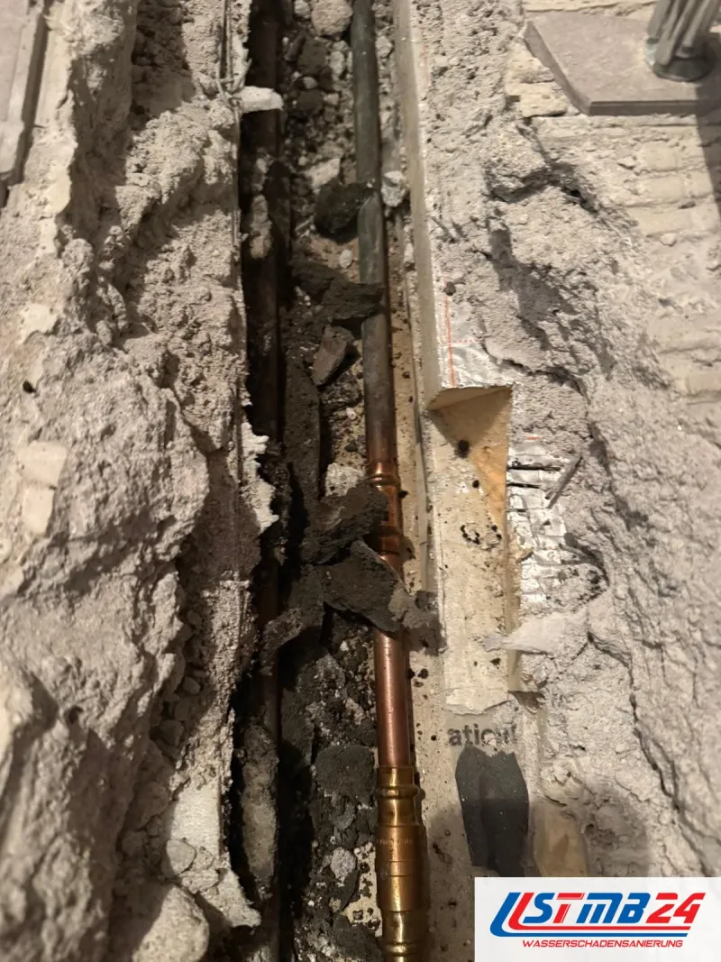 Leckortung in Grömitz: Rohrgraben im Estrich aufgestemmt, ein neues Kupferrohr mit Pressfittings liegt neben der alten Leitung