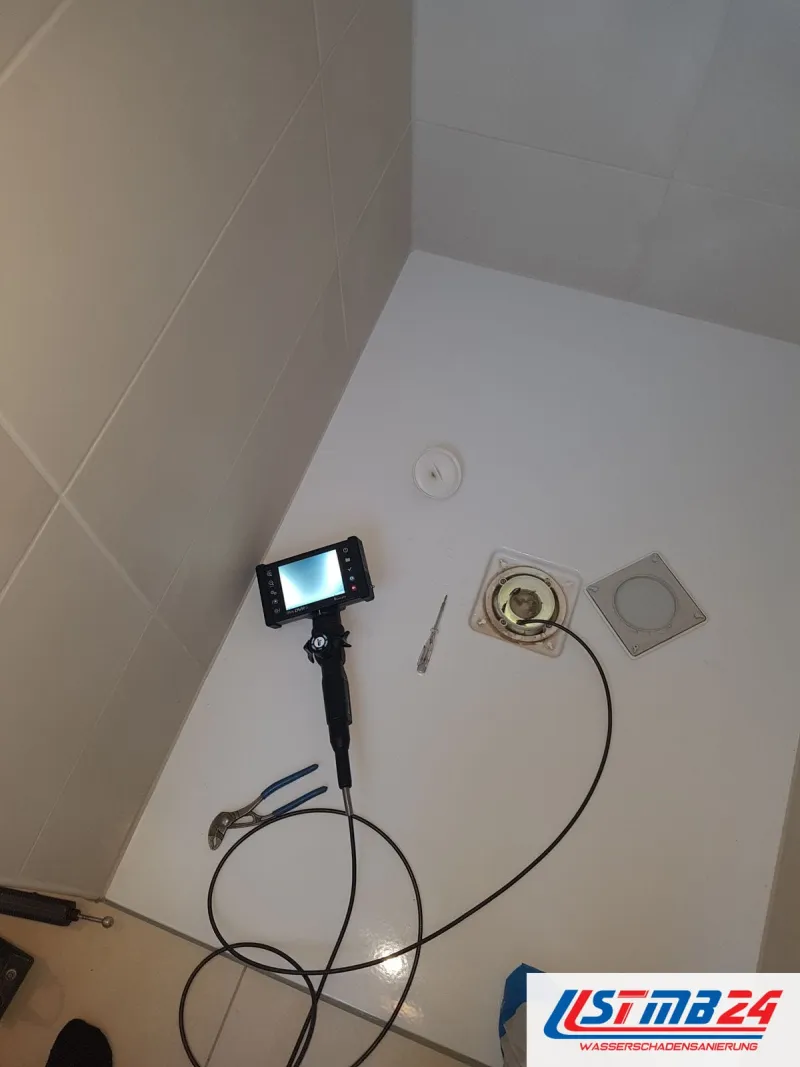 Leckortung in Grömitz: Videoendoskop mit Monitor in der Duschtasse, das Kabel steckt im offenen Bodenablauf, daneben Werkzeug