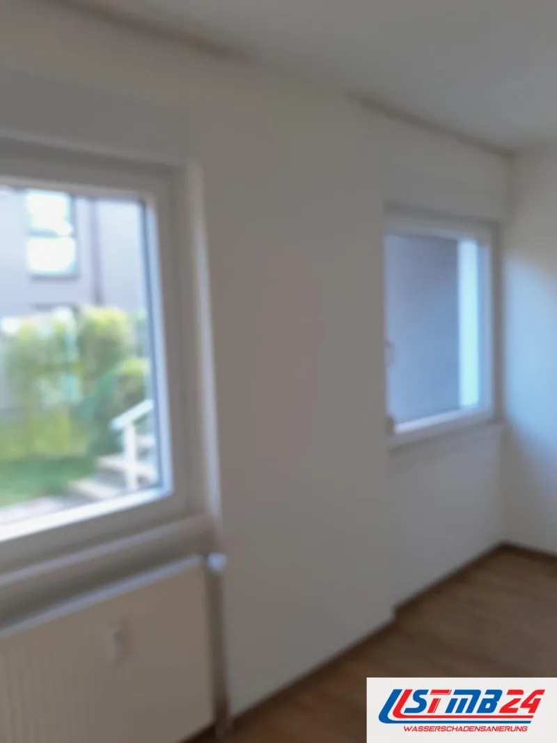 Maler in Grömitz: frisch gestrichener Raum mit zwei Fenstern, Heizkörper unter dem linken Fenster, draußen eine Treppe