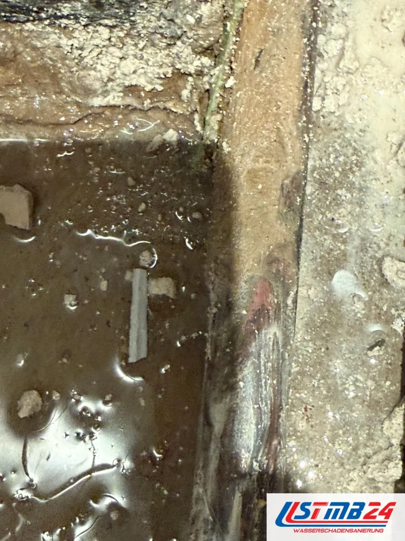 Wasserschaden Notdienst in Grömitz: am aufgestemmten Wandfuß steht Wasser zwischen Estrichbrocken
