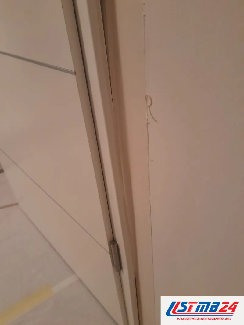 Tischler in Grömitz: Türband an der weißen Zarge, daneben ein Riss in der Wand und eine abstehende Fuge