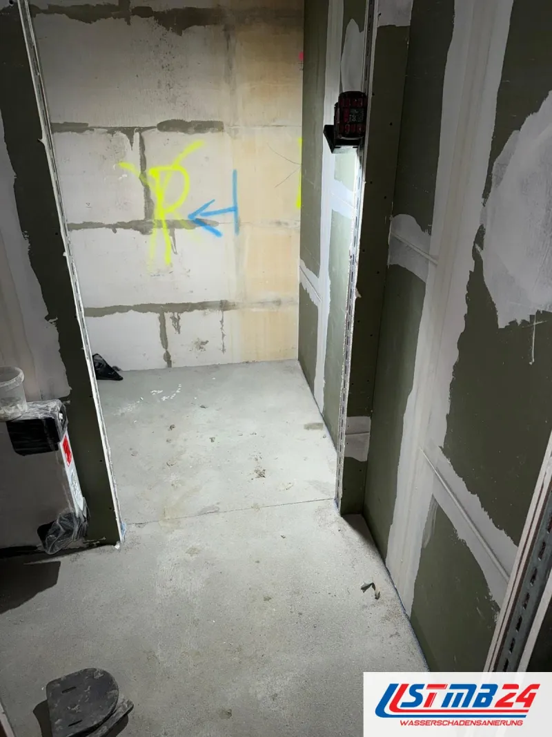 Trockenbau in Grömitz: schmale Kammer aus grünen Gipsplatten vor einer Kalksandsteinwand mit Sprühmarkierungen