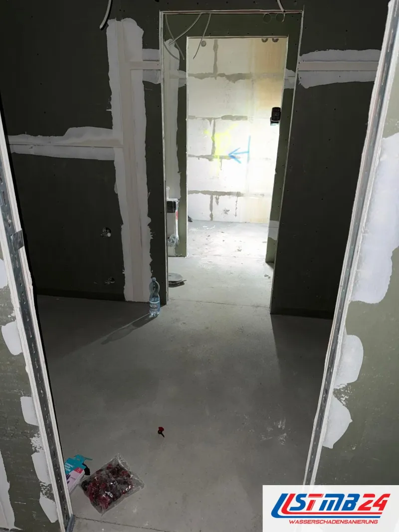 Trockenbau in Grömitz: Durchgang zwischen Wänden aus grünen Gipsplatten, dahinter Kalksandstein mit Sprühmarkierung