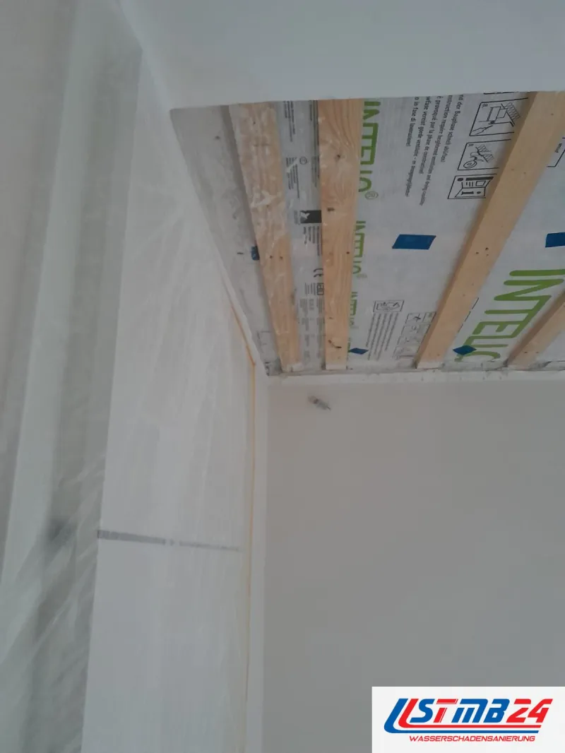 Trockenbauarbeiten an der Decke: Dampfbremsbahn Intello und Holzlattung vor dem Beplanken, die Wand mit Folie abgedeckt