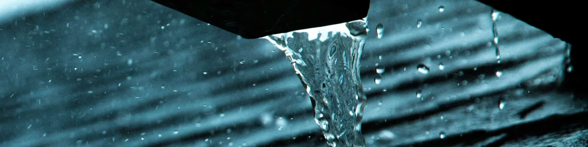Ursachen von Wasserschäden: Regenwasser strömt aus einer Dachrinne