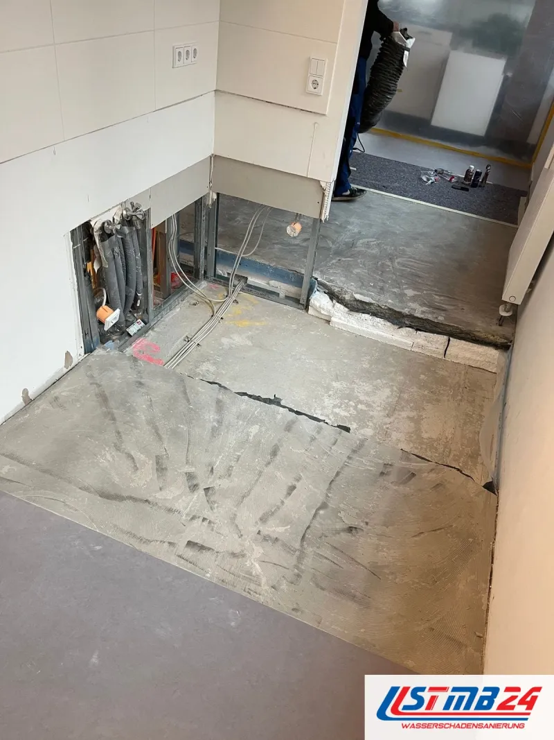 Küche mit aufgeschnittenem Estrich und geöffneter Vorwand, im Hintergrund eine Staubschutzwand aus Folie